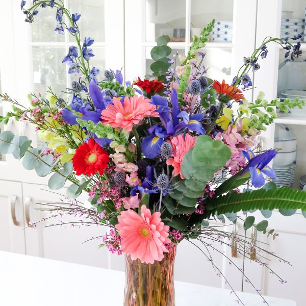 Close up of colorful valentines day flower arrangement in pink vase