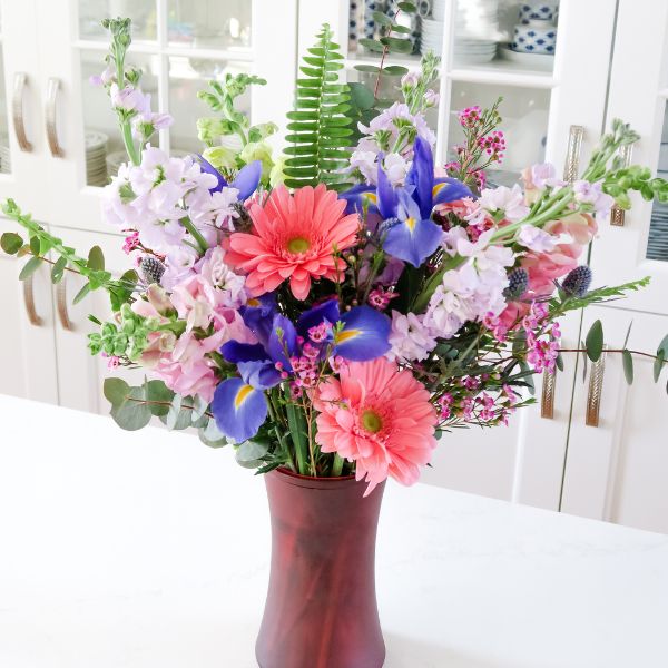 Square image of colorful floral valentines arrangement in red vase