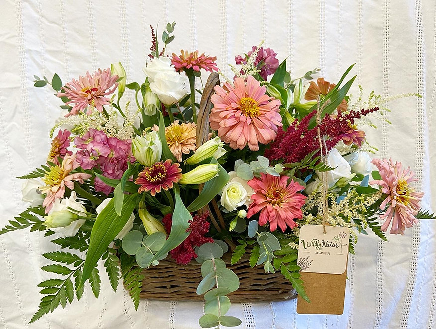 Flower basket arrangement in pinks, whites, and reds.