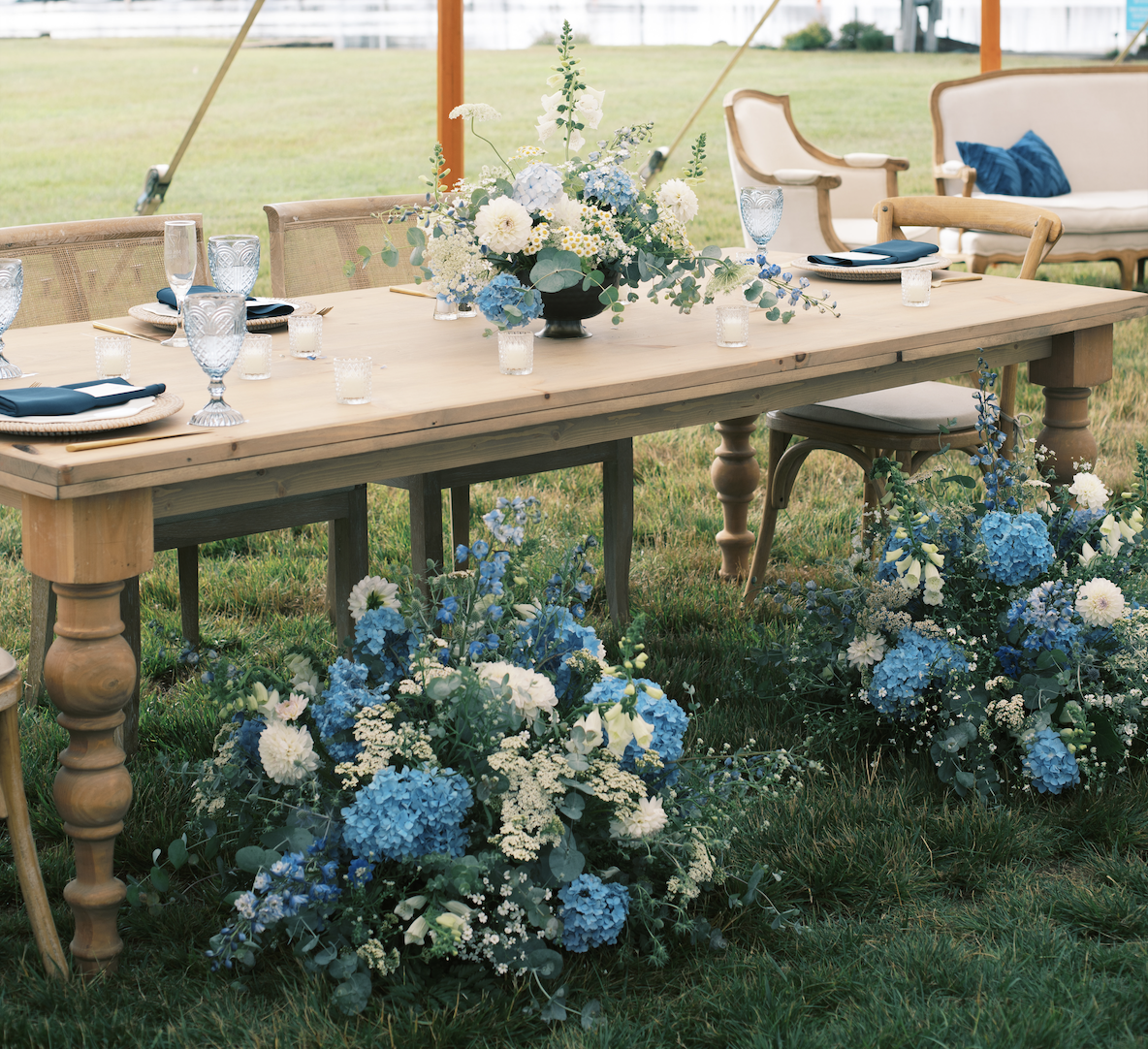Blue and white flowers at wedding on sweetheart table in tent