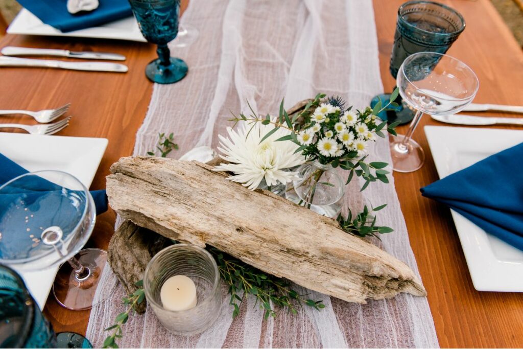 reception table with drift wood and green and white flowers