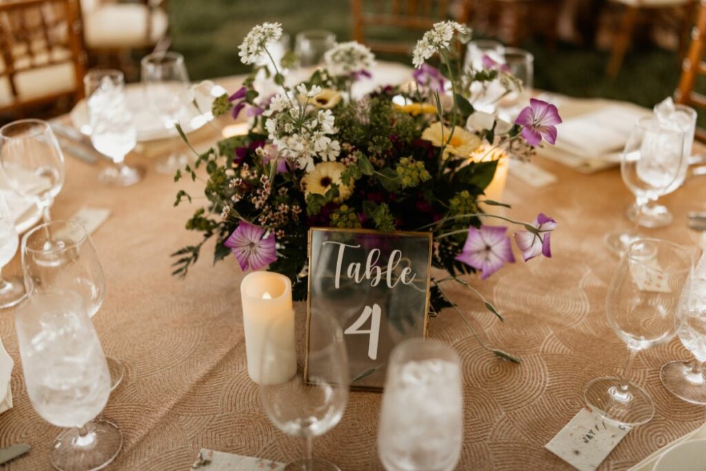 colorful spring flowers and pillar candles on round table at wedding reception