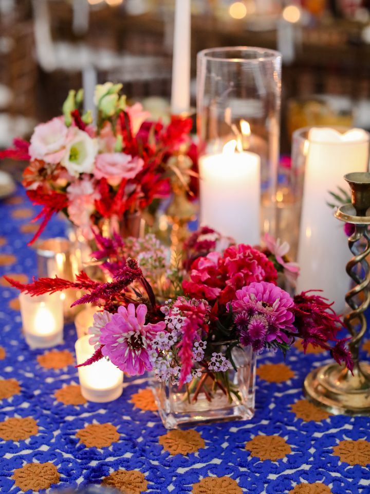 colorful flowers with round tables and pillar candles in wedding reception