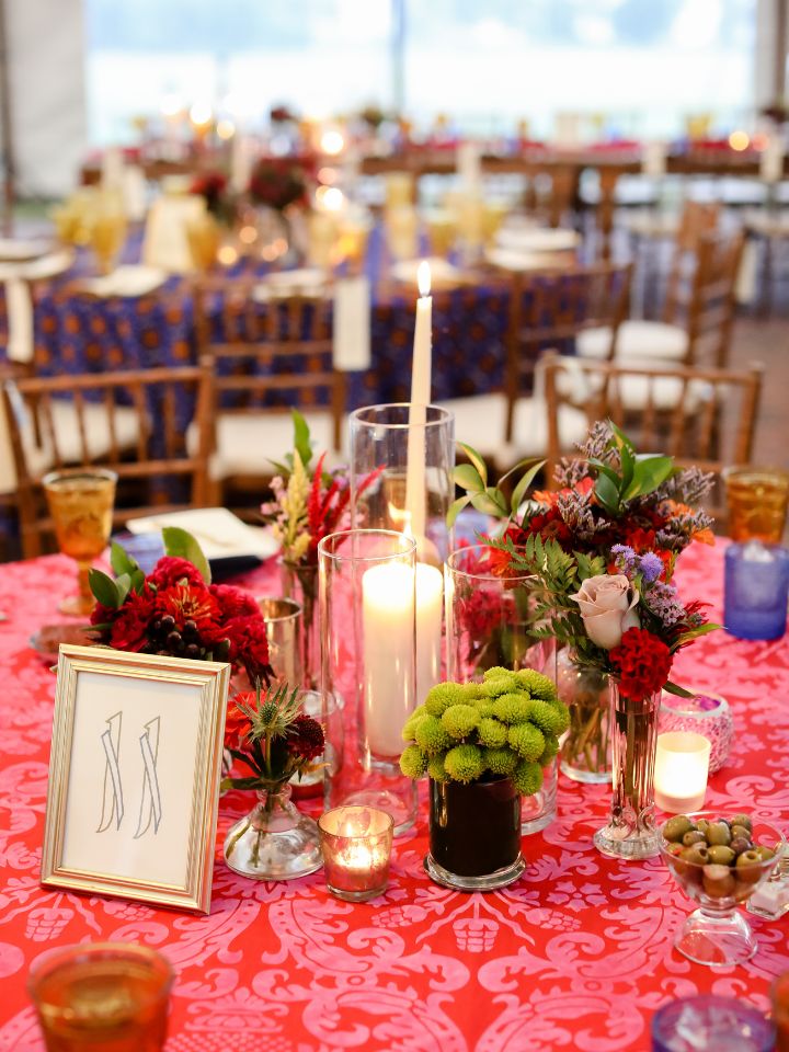 round reception table with colorful flowers and taper candles