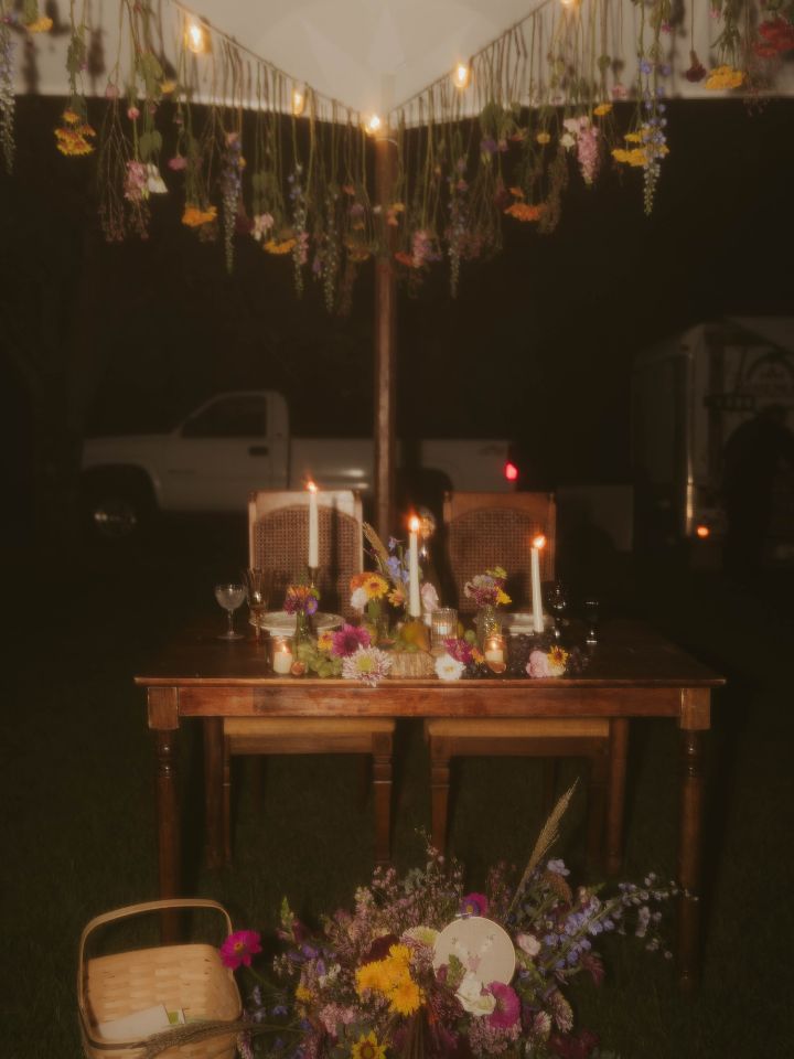 floral installation with sweetheart table under the tent with bridal bouquet