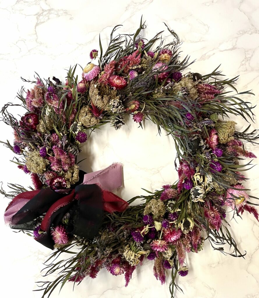 Dried Flower Wreath in moody jewel tones of burgundy and magenta.