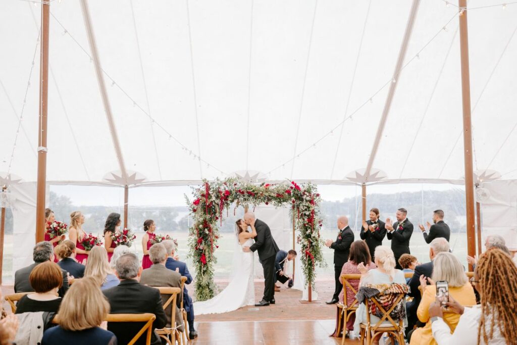The kiss under the chuppah, inside of a sailcloth tent.