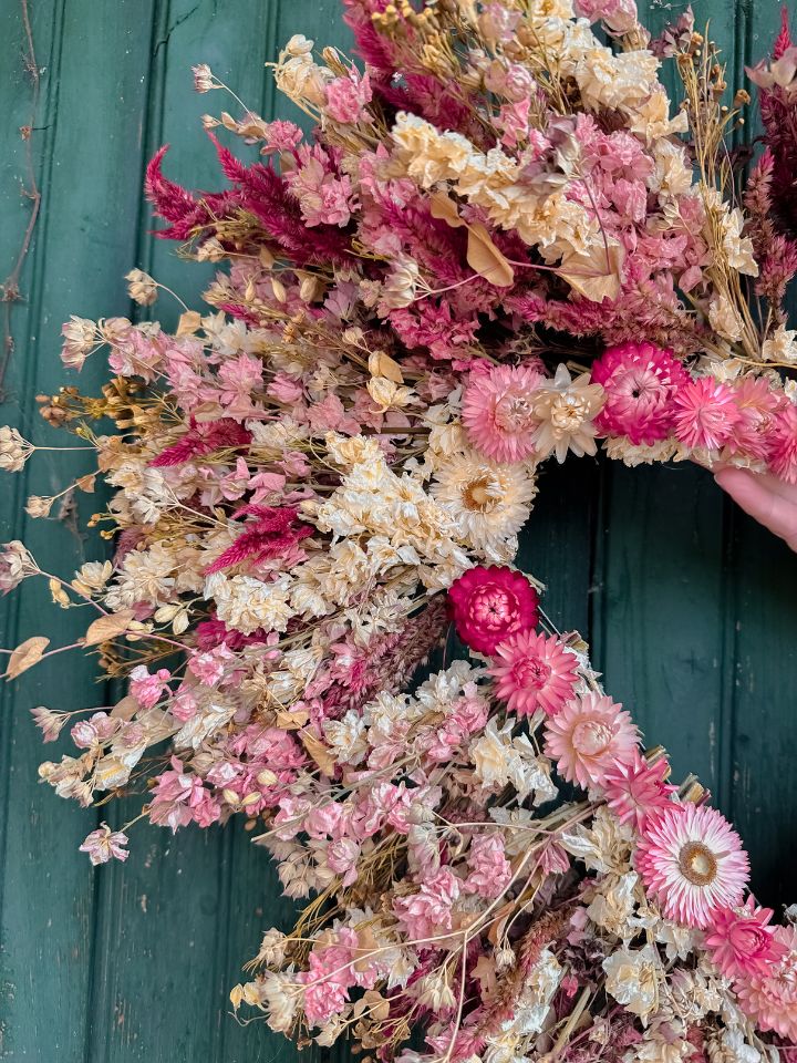 Close up image of pink, white, and red dried florals on a dried wreath.