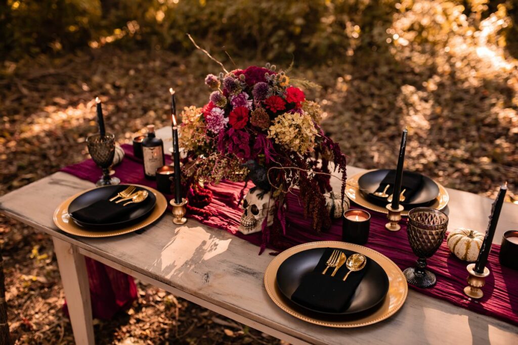 Table in the woods set with moody spooky halloween style table settings.