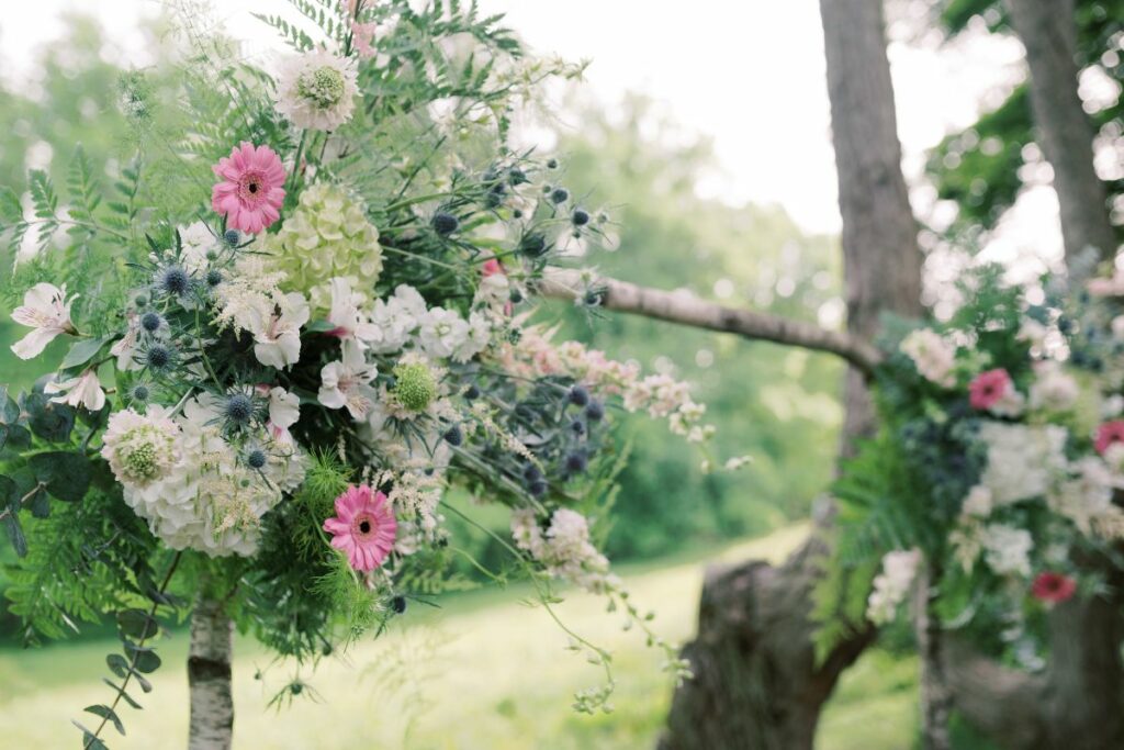 Close up of blue, pink, and white flowers on a wedding arch.