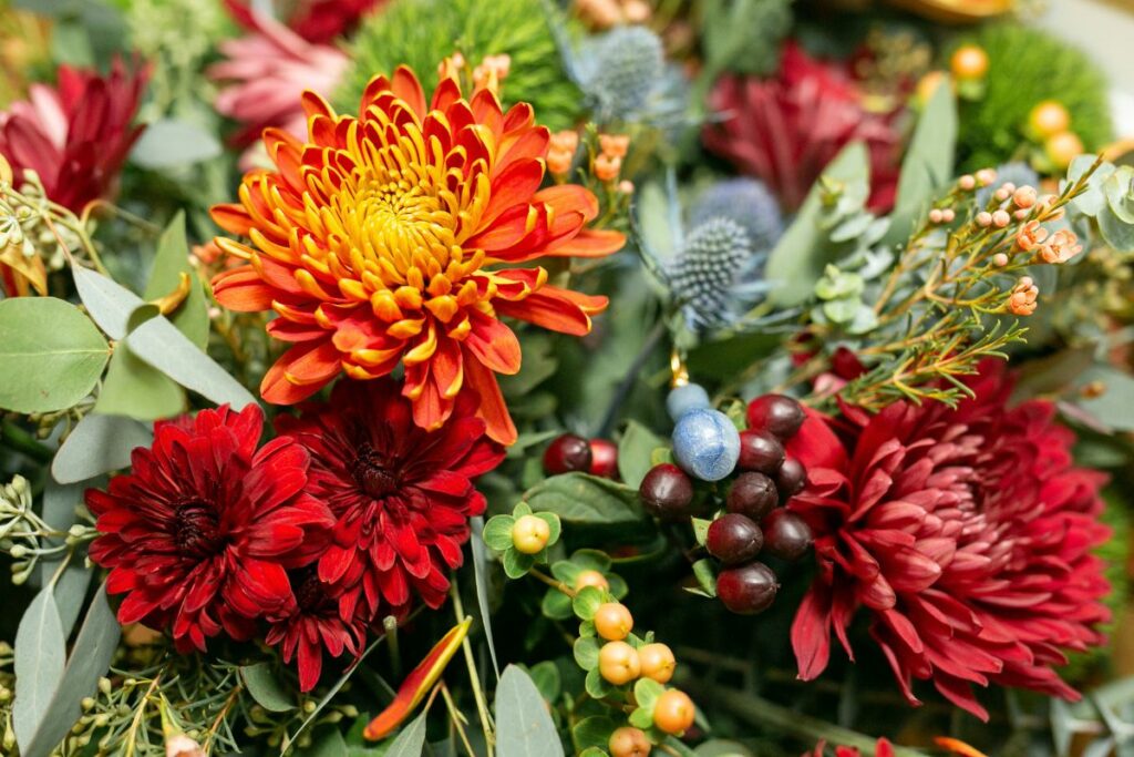 Close up of autumn wedding flowers bouquet with mums and eryngium.