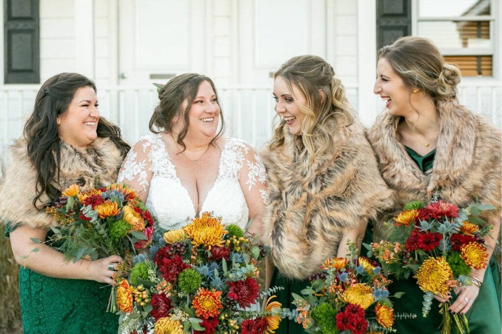 Bride and Bridesmaids in furs holding wedding flowers.