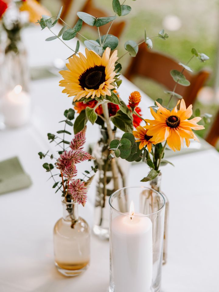 Wildflower summer bud vases on a reception table.