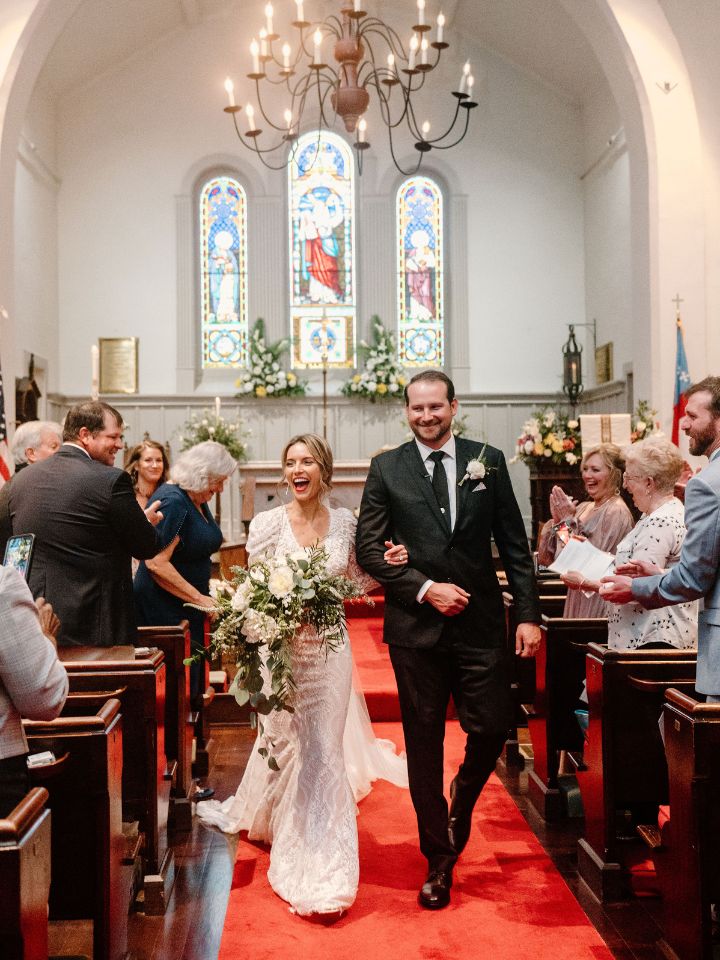 Bride and Groom walk back down the aisle of a church after their wedding ceremony.