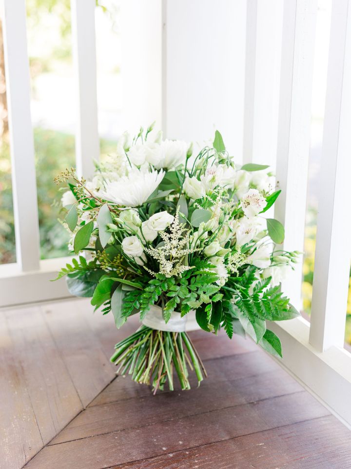 Rounded bridal bouquet of white and green wedding flowers.