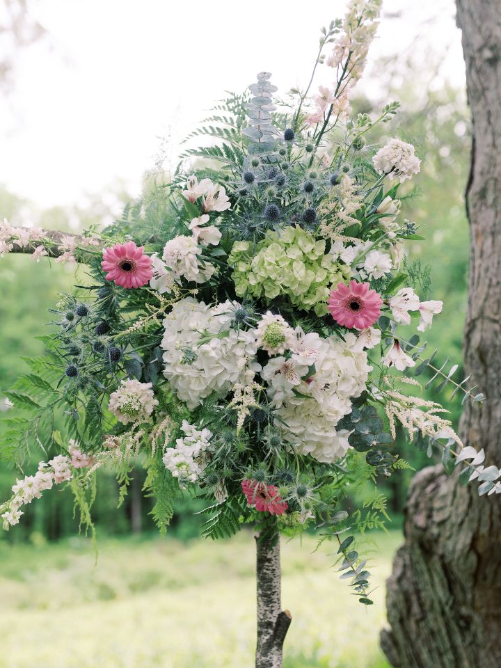 Close up of flowers on a wedding ceremony arch.