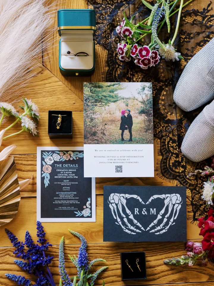 Flat Lay style photo of wedding invitation and florals for a spooky theme wedding.