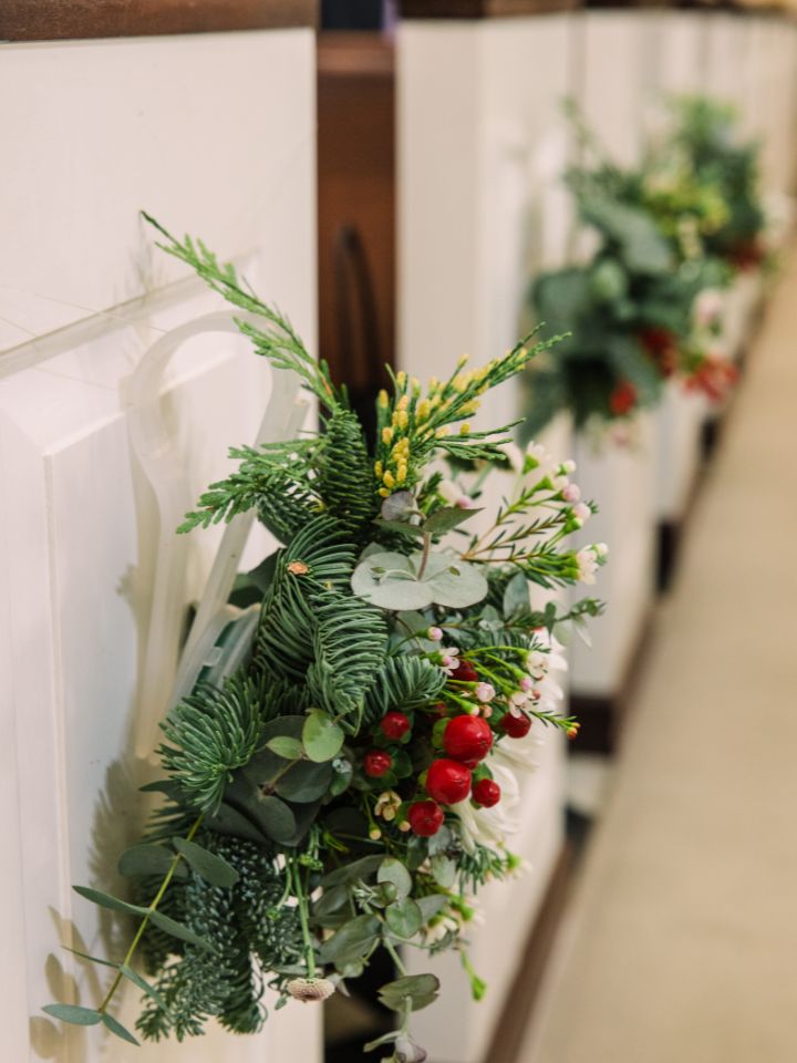 Christmas floral pew clips at a church.