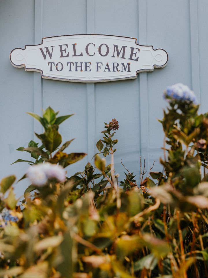 Welcome to the Farm sign on the side of a pale blue building.