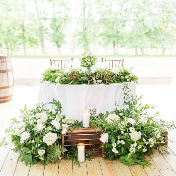 Sweetheart Table at Wedding with Greenery and White Florals Surrounding it