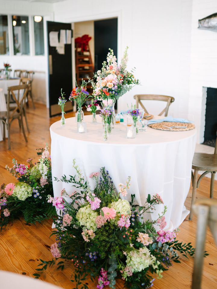 A sweetheart table at a wedding reception with pastel spring flowers.