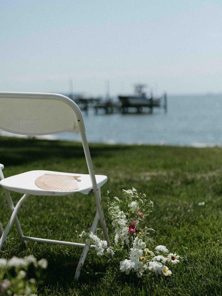 In ground florals line the aisle at a spring waterfront wedding
