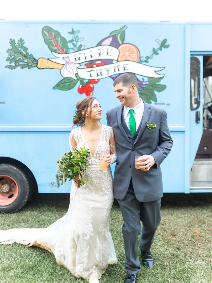 Bride and Groom looking at each other walking towards the camera in front of a food truck