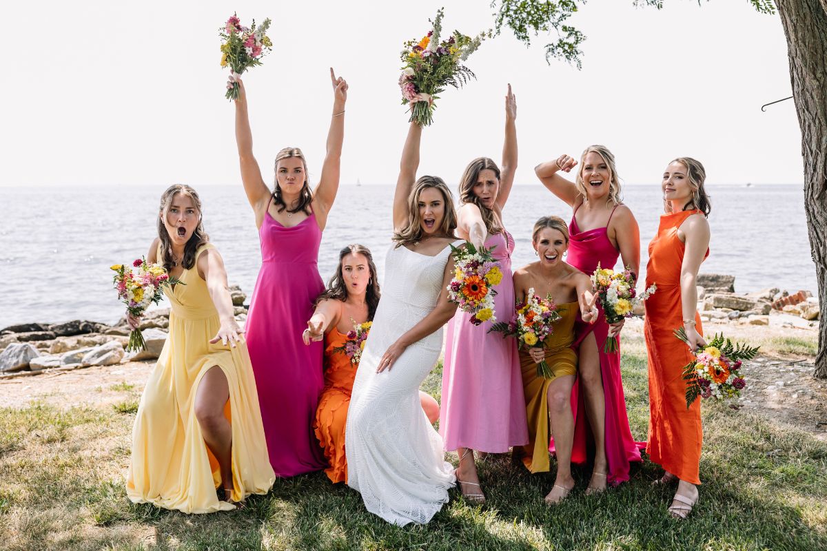 Bride and bridesmaids pose for a photo in bright summer colors.