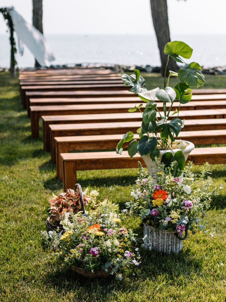 Aisle entrance for outdoor wedding ceremony with potted plants.