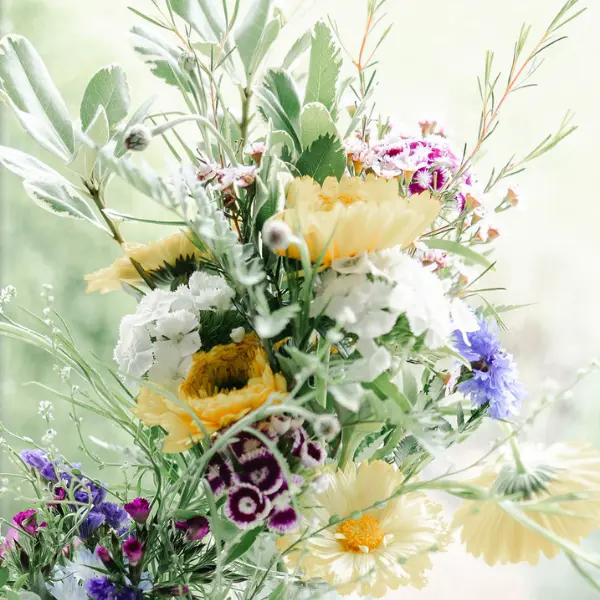 Up close view of a spring bouquet with yellow, purple and green accents