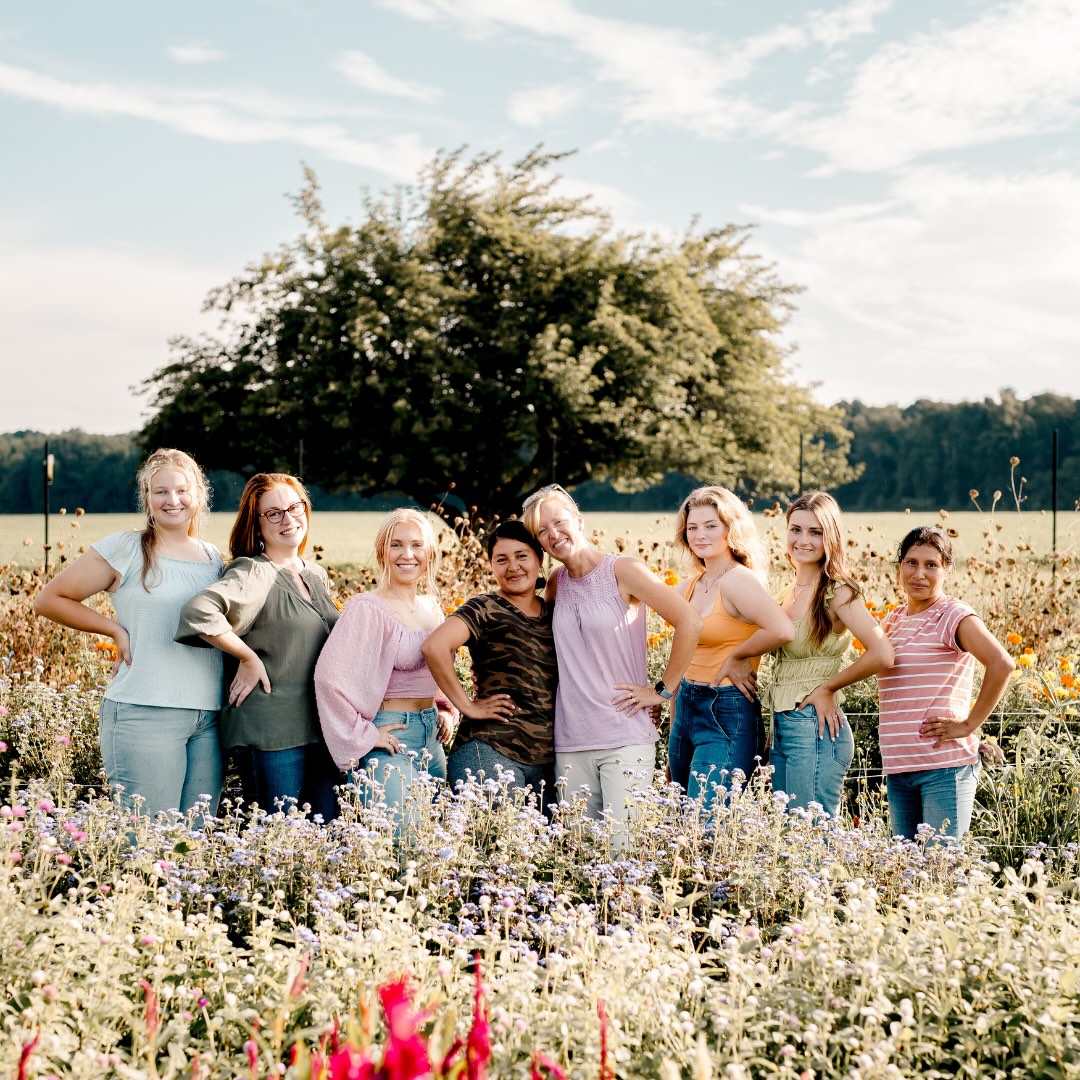 Group photo of the team behind Wildly Native Flower Farm, standing in the flower field together smiling at the camera