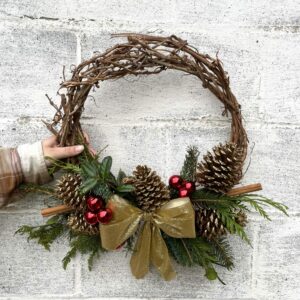 Medium Grapevine Wreath with gold bow and Christmas decor.