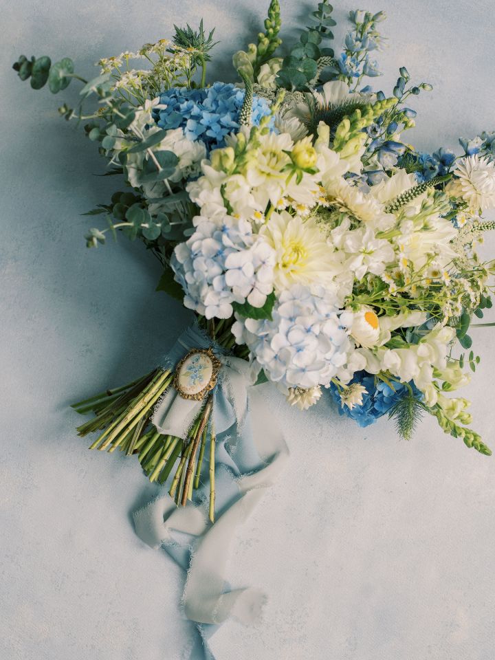 Wedding bridal boquet with blue and white flowers and greenery