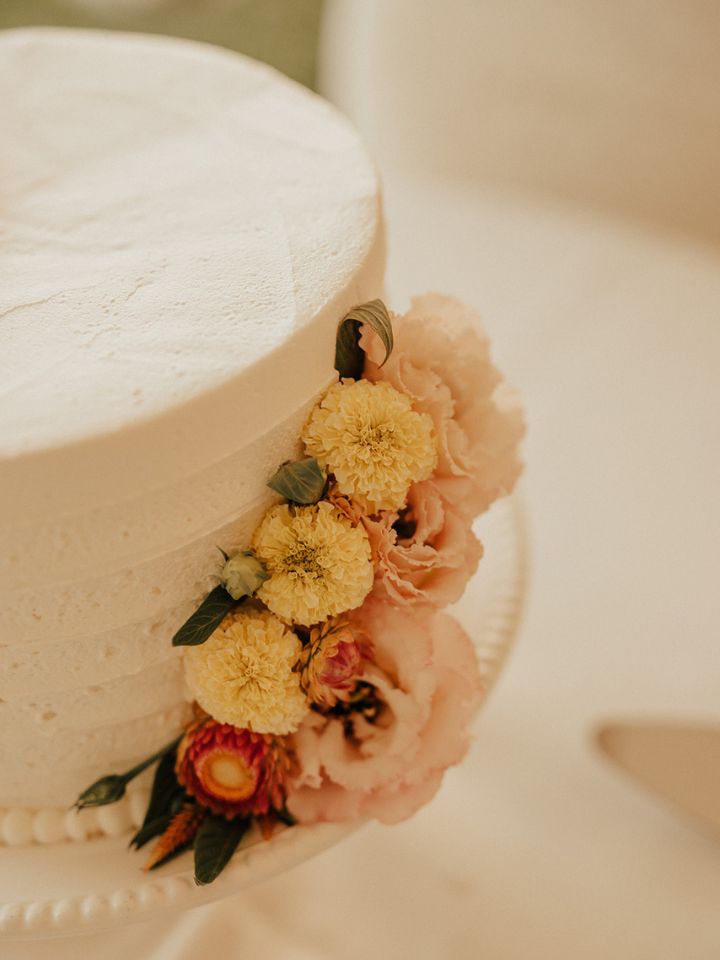 White wedding cake with fresh flower decorations