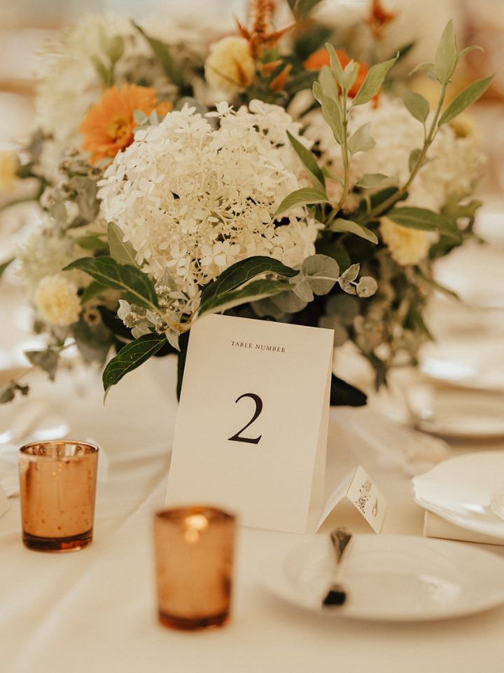 Closeup of a floral compote with rose gold votive holder.