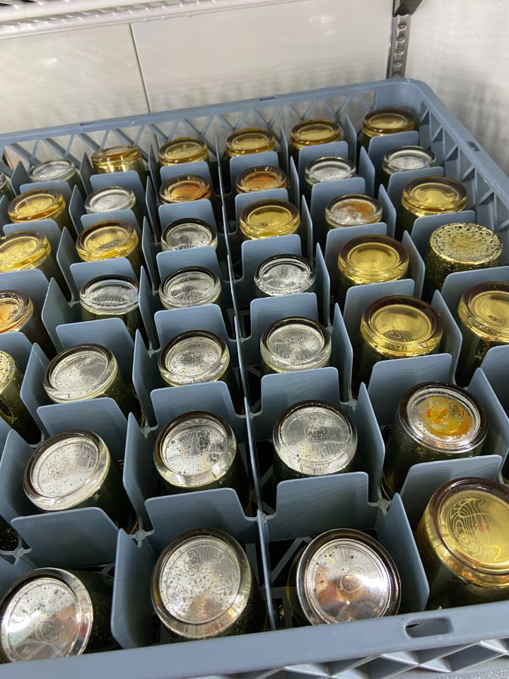 A rack of silver and gold votive candles stits upside down in a cooler.