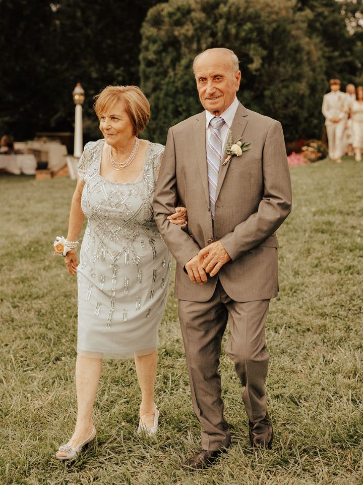 Older couple walk down the aisle at a wedding