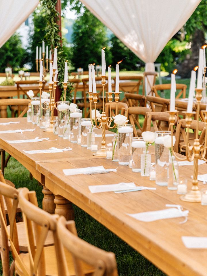 Harvest wood wedding reception table with floating candles, votives, and candelabra.