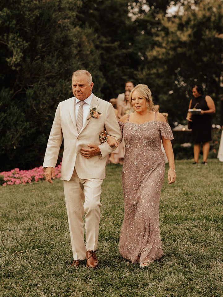 Parents of the groom walk down the aisle