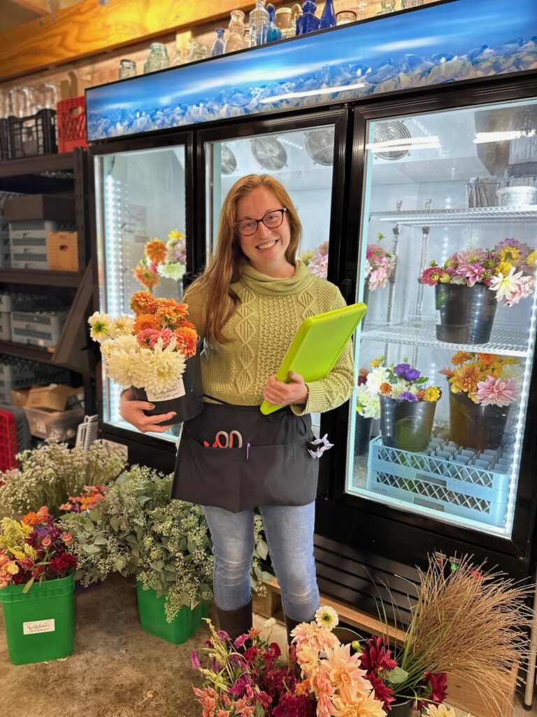 Nicole stands in front of the flower cooler.