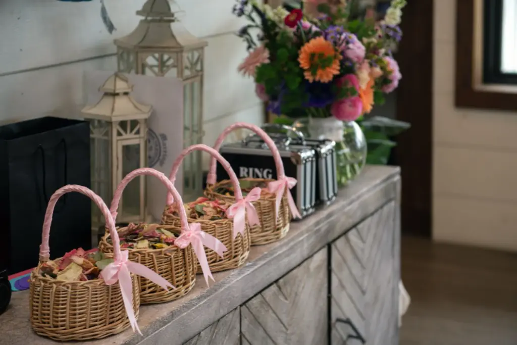 A shelf with 4 baskets of flower petals for flower girls and 2 black briefcases that say "ring security" for Jr Groomsmen