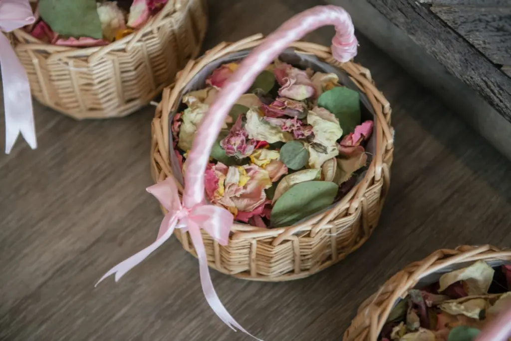 Basket decorated with pink ribbon and filled with dried flower petals