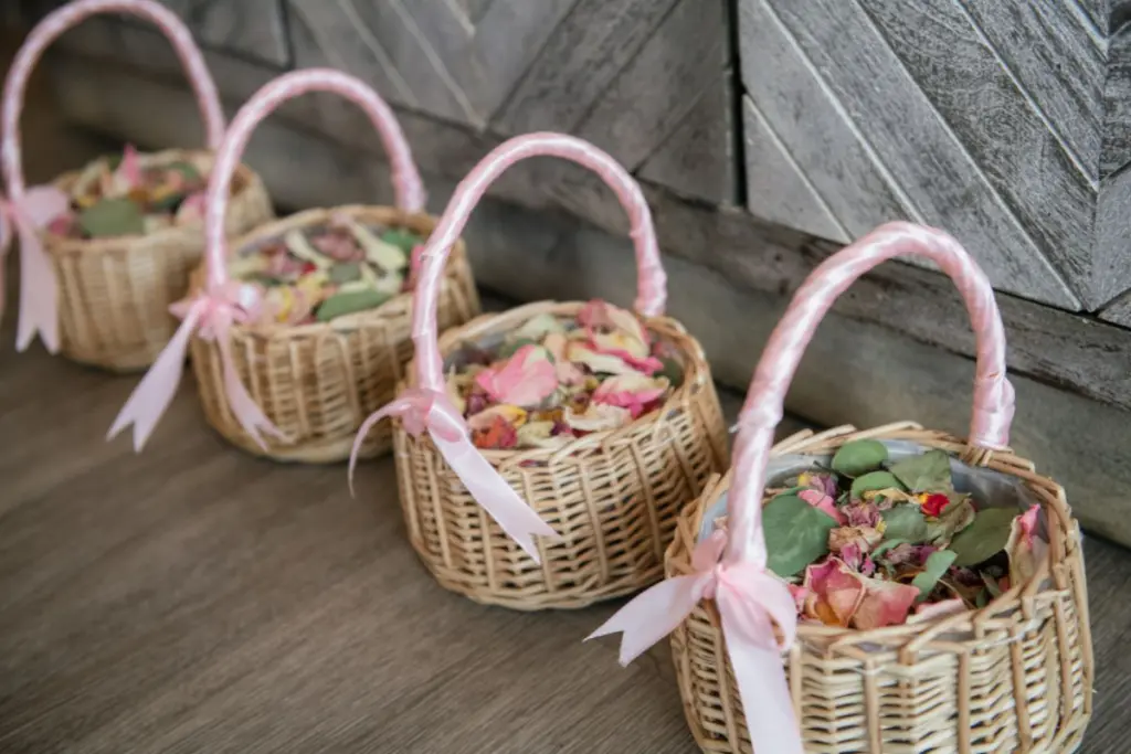 Flower baskets for flower girls tied with pink ribbon and filled with dried flower petals