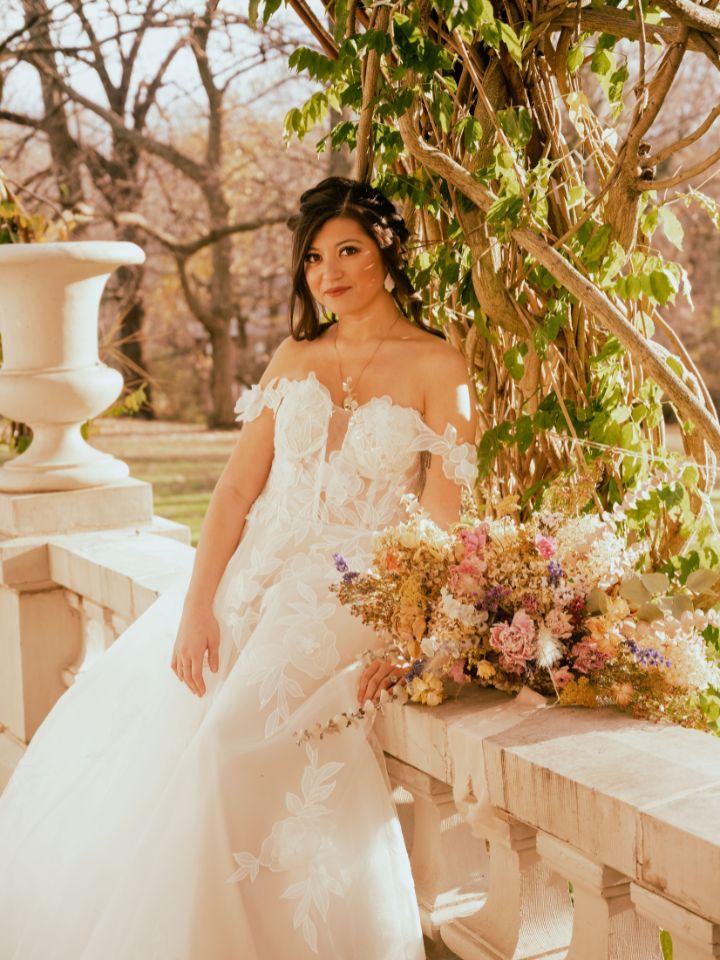 Bride sits with dried bouquet.