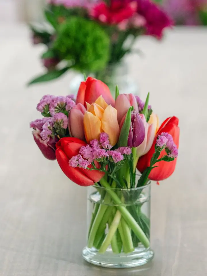 Bud vase filled with pink tulips and purple flowers for cocktail hour tables