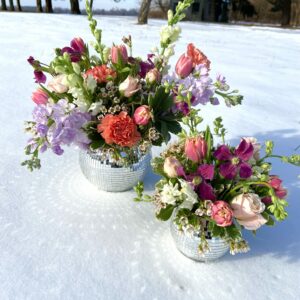 Disco Ball Flower Arrangements in bright pinks and purple for Valentines Day sit in the snow.