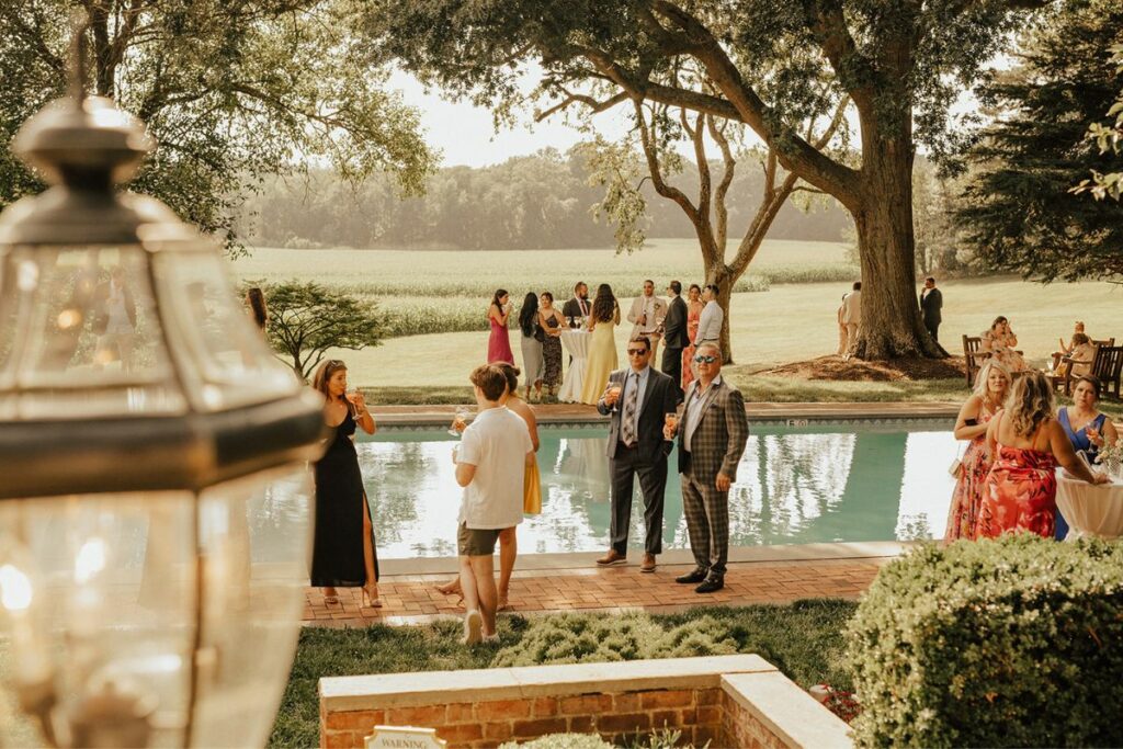 Guests mingle by the pool at a July wedding.