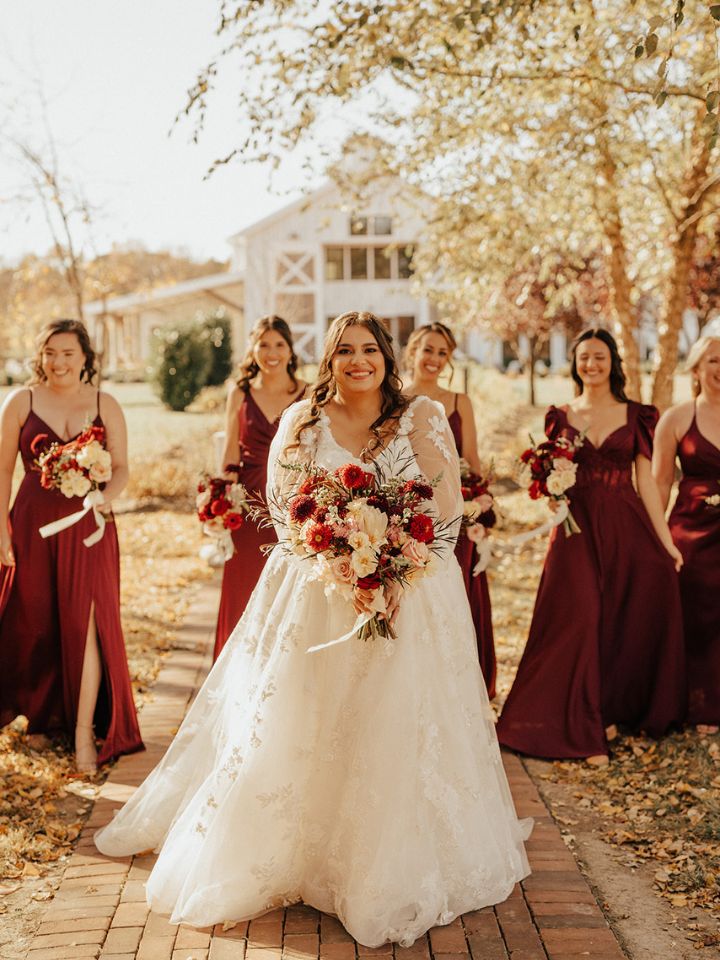 Bride and her bridesmaids hold their burgundy and ivory wedding bouquets from Wildly Native Flower Farm.