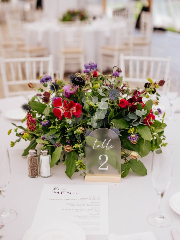 Vibrant jewel tone flowers from Wildly Native Flower Farm on a white table linen.