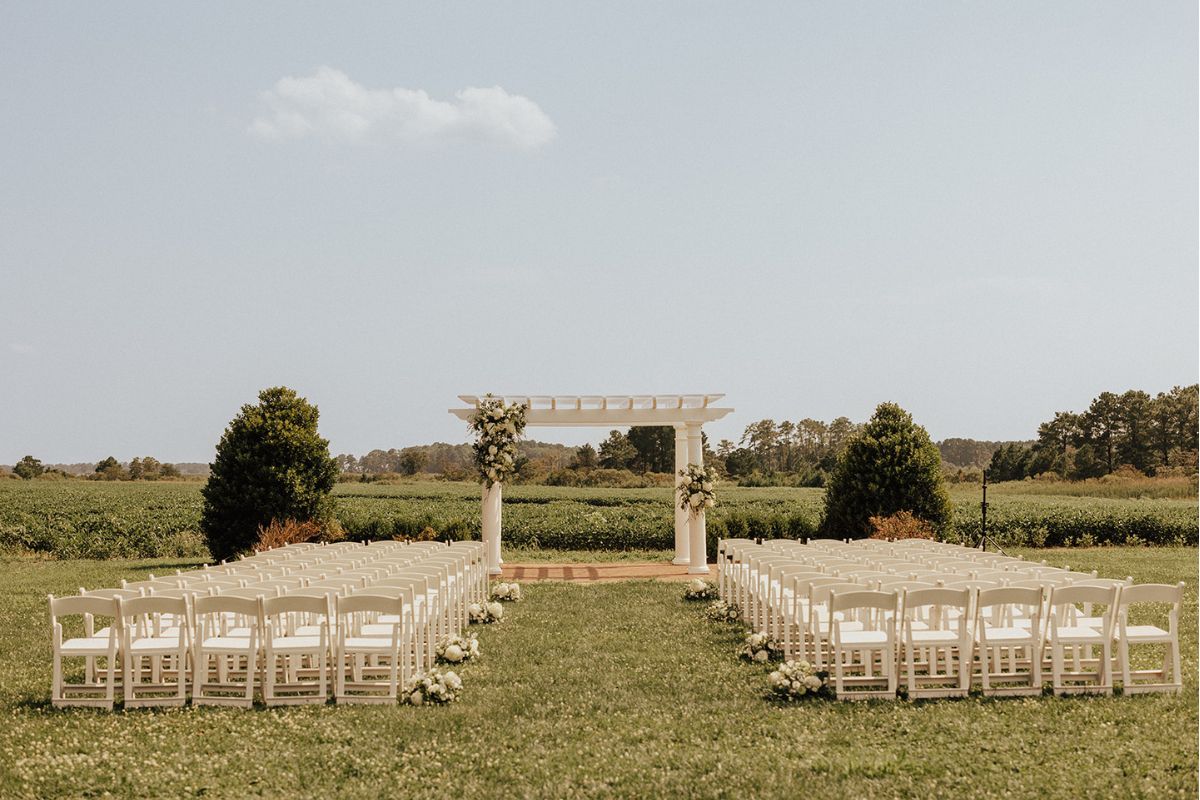 The large white pergola decorated in wedding flowers from Wildly Native Flower Farm as the Kent Island Resort Florist